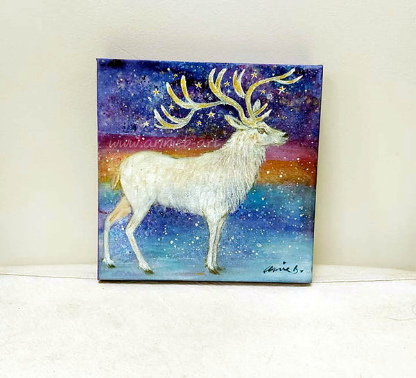 The majestic white stag stands proud surrounded by magic and stars under a snowy sky.   Mixed media on deep edge boxed canvas with a hint of gold and sparkle by visonary artist annie b.   Size 25cm x 25cm ready for your walls