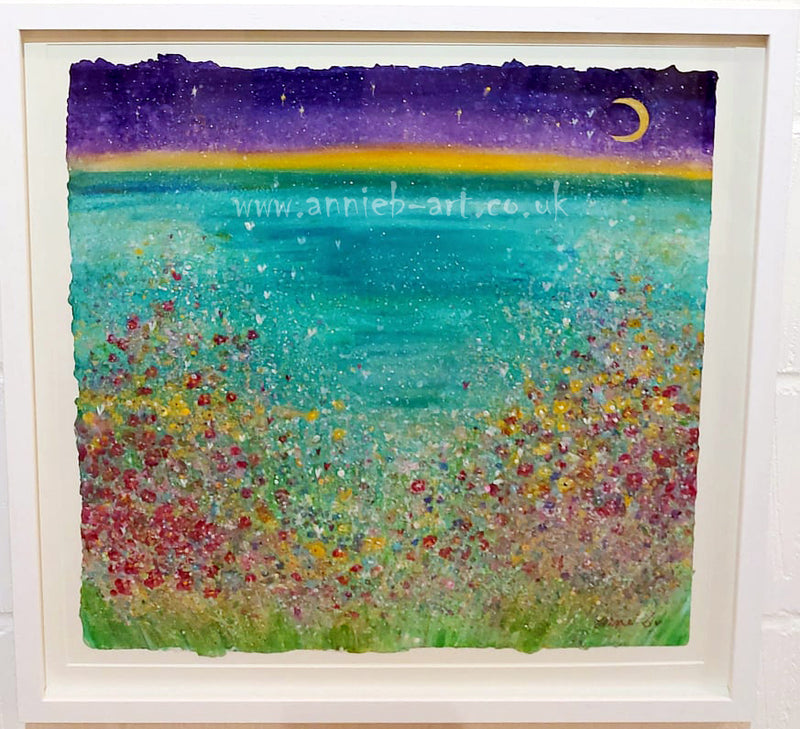 Cornish wild flowers dance happily above a Cornish cove under a new moon.  A large mixed medium painting on hand made paper, mounted and framed with a white washed wooden frame ready for your walls to uplift any space.